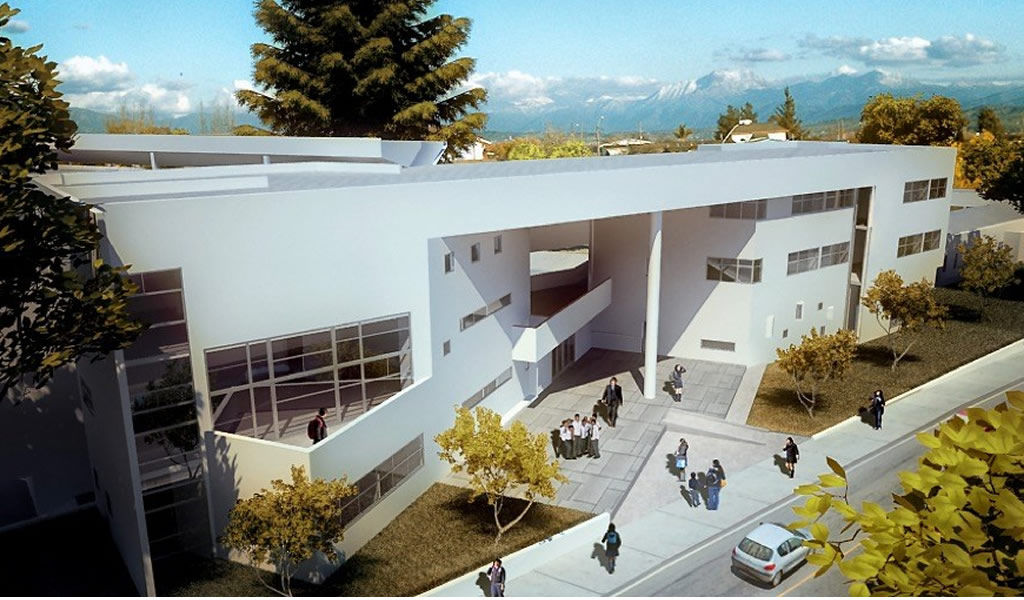 Vista aérea de un edificio educacional blanco con patio de acceso y cordillera al fondo